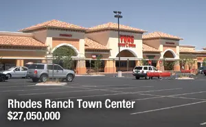 A large parking lot with cars parked in front of it.