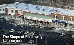 A parking lot with cars parked in it and a building on the corner.