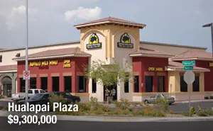 A large building with two windows and a parking lot.